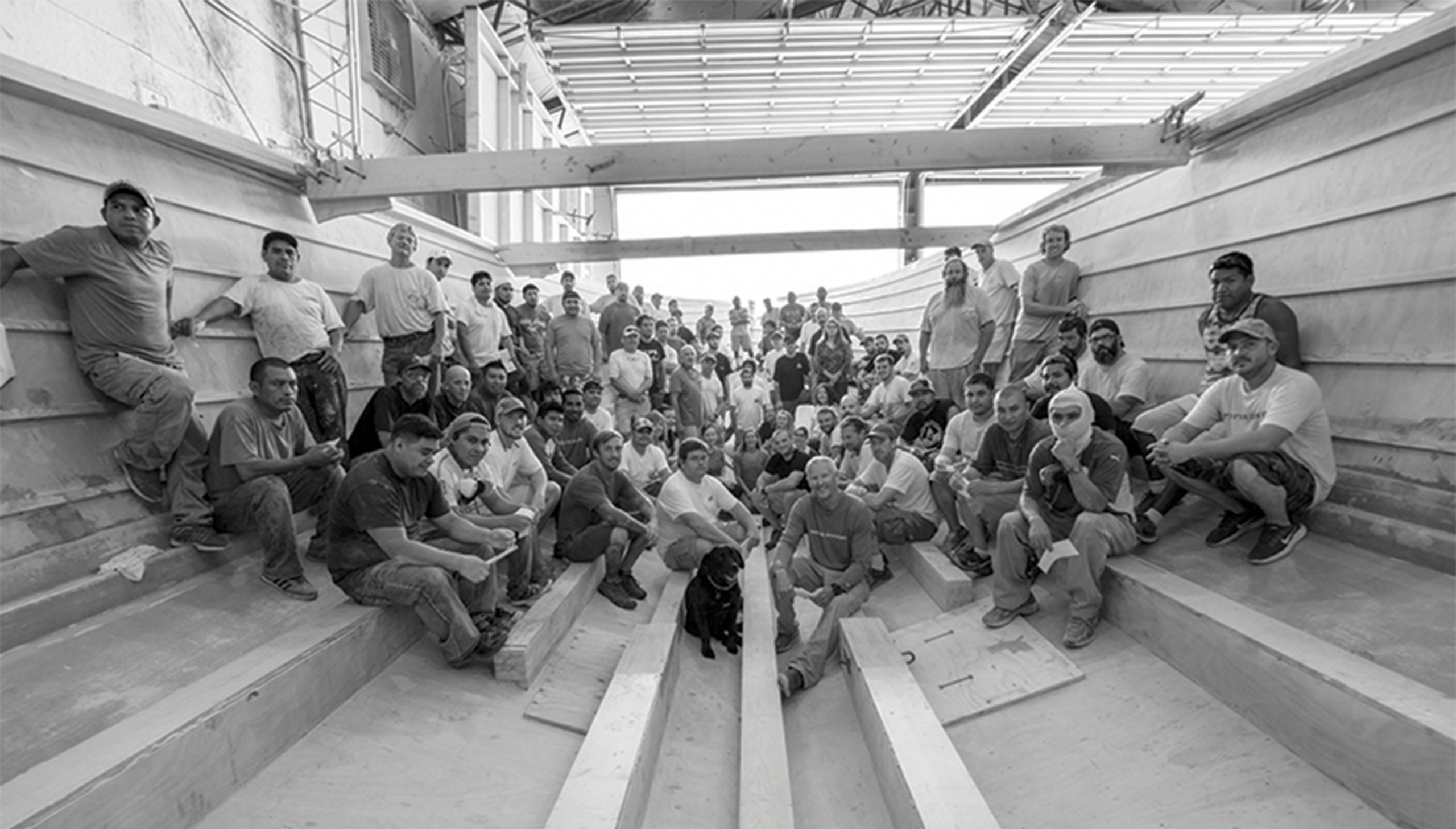 Black and white image of Bayliss Boatworks workers posing for a picture inside a hull